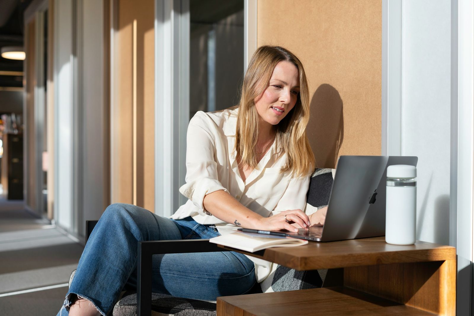A professional woman researching on a laptop in a bright, modern office